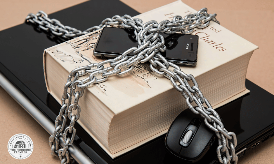 Photo showing a book, laptop, and cell phone wrapped in chains.