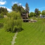 An aerial of Buttermilk Falls Inn's grounds, showing green grass against a blue sky with guest facilities in the background.